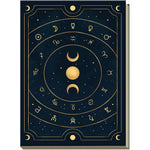Decorative Astral Journal notebook cover with celestial design featuring moons, stars, and astrological symbols on a dark blue background.