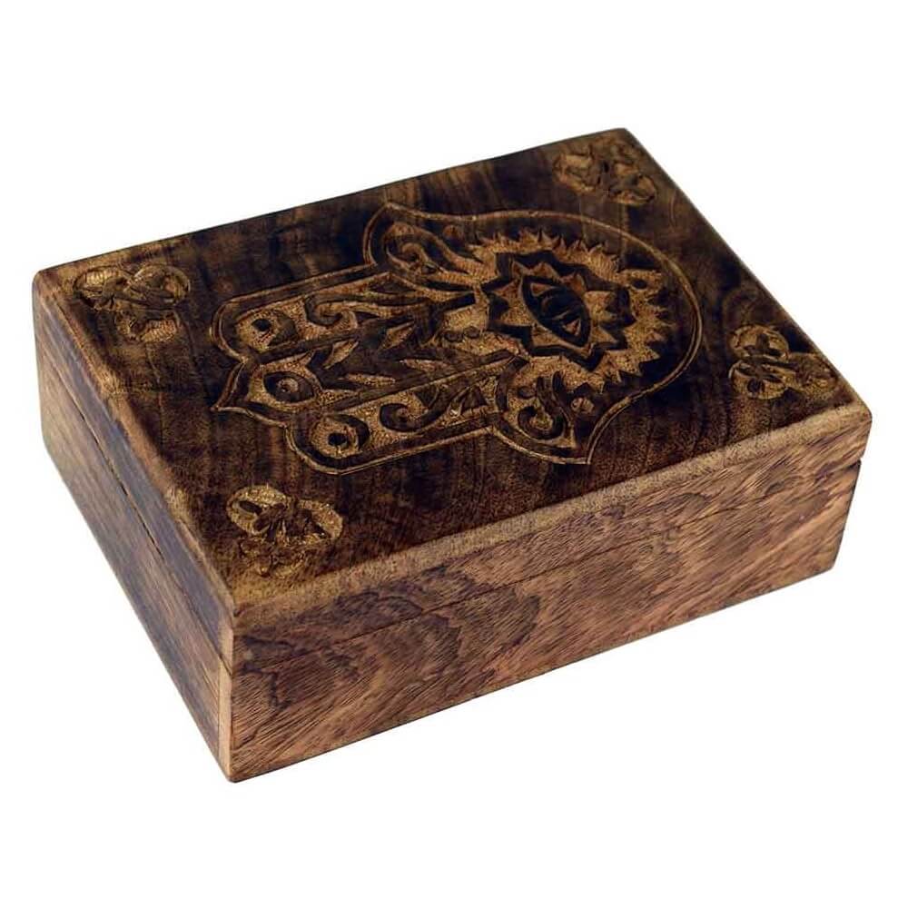 A wooden trinket box with carved Hand of Hamsa detail on the lid