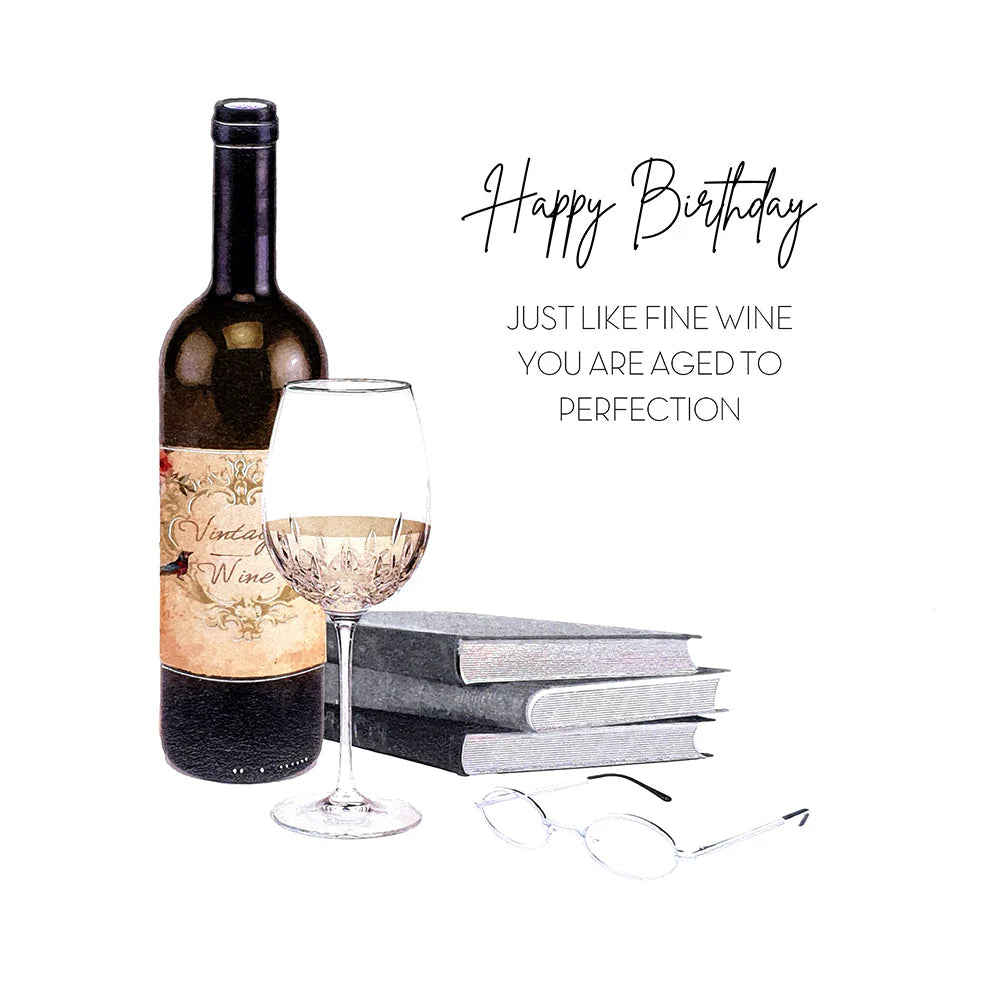 A watercolor-style birthday gift illustration featuring a dark wine bottle, a partially filled wine glass, stacked books, and eyeglasses, with the text 'Happy Birthday' and 'JUST LIKE FINE WINE YOU ARE AGED TO PERFECTION'.