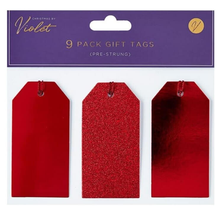 Red Christmas gift tags with glittery texture on a 'Christmas by Violet' branded packaging.