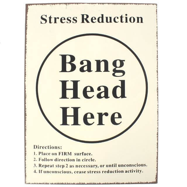 A rectangular tin sign with a cream coloured front, black text, displaying the phrase 'Stress Reduction Bang Head Here' with directional instructions.