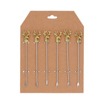 Six decorative cocktail picks with gold stag, reindeer head handles and silver metal picks, displayed on a brown cardboard backing.