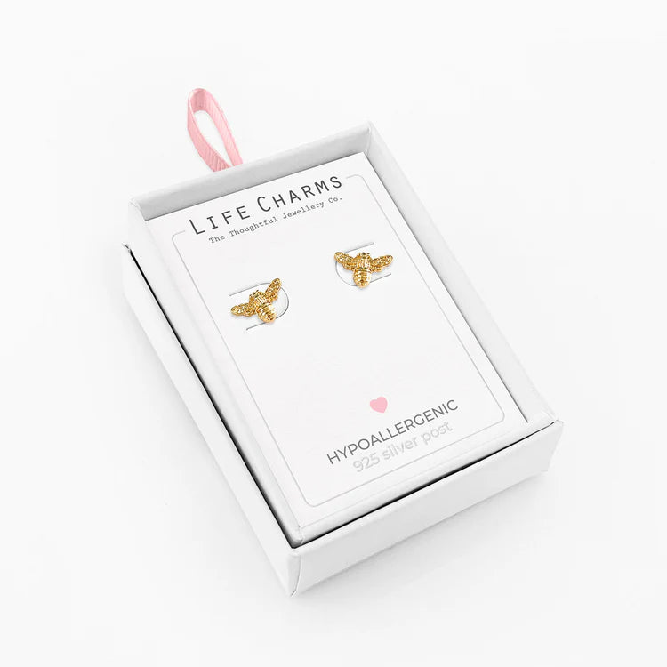 Gold bee-shaped earrings in a 'Life Charms' box on a white background