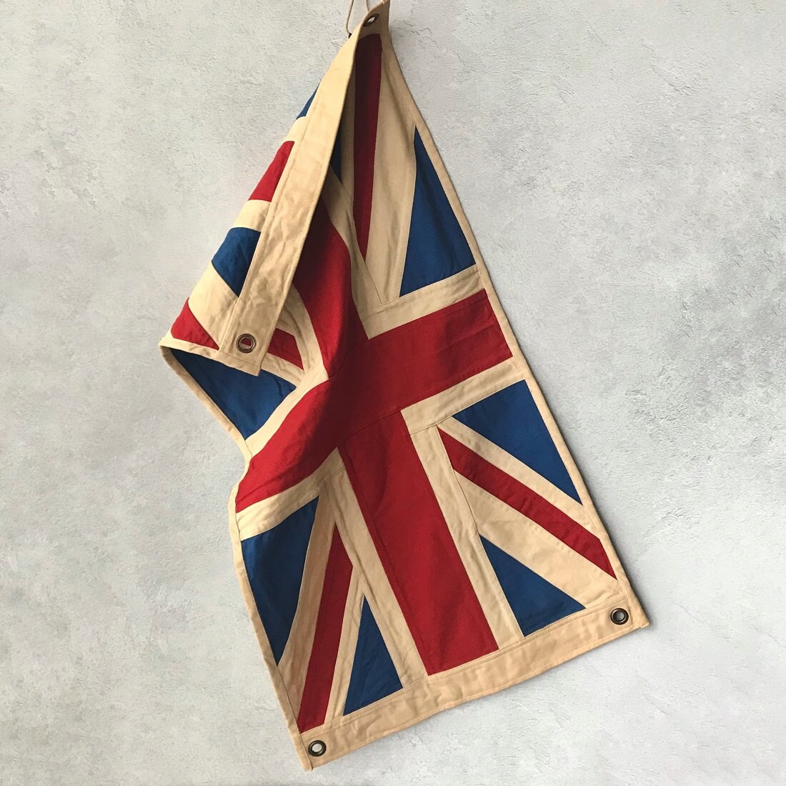 Small vintage Union Jack flag on a textured gray background by Woven Magic